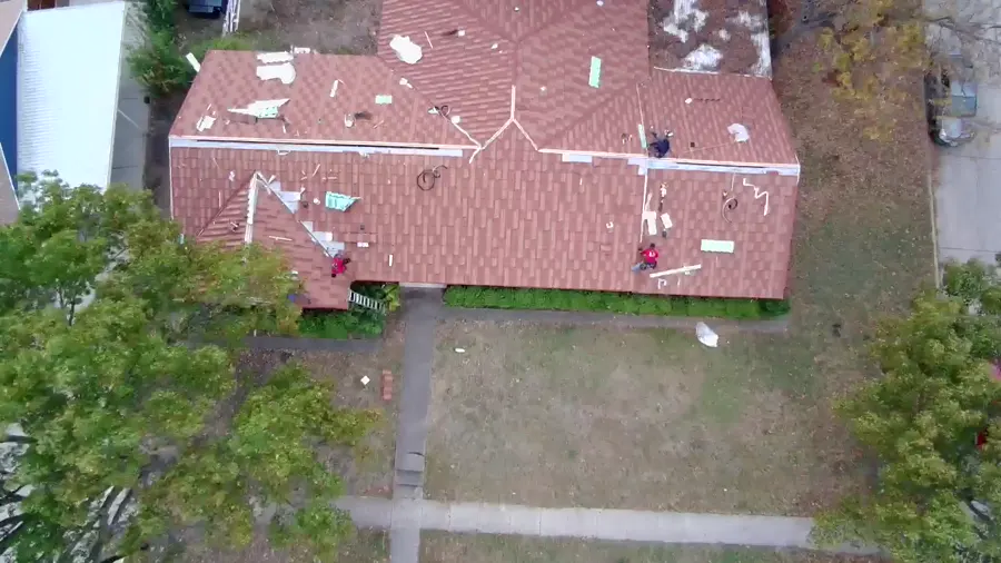 Drone view of a tile roof mid-job from the street side