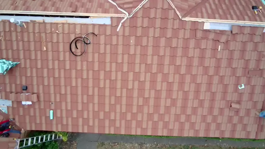 Top-down drone view of a tile roof mid-job